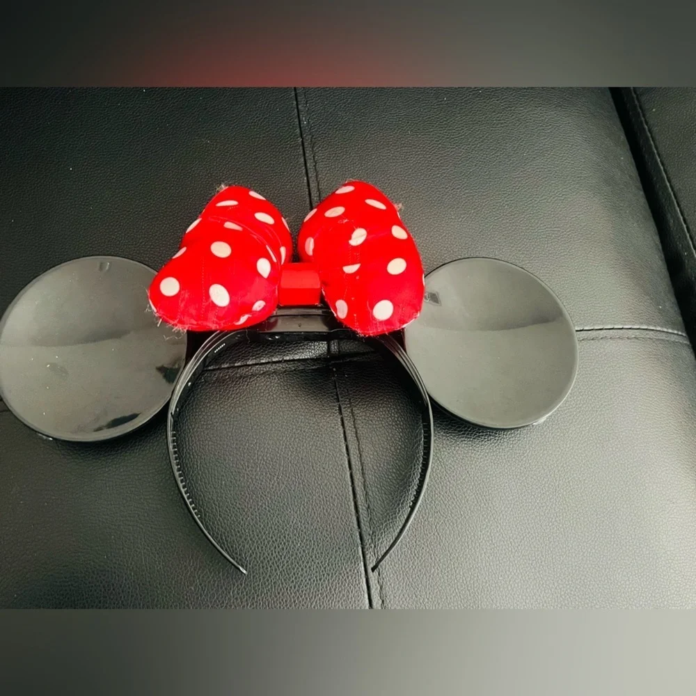 Minnie Mouse ear headband with a red and white polka dot bow.